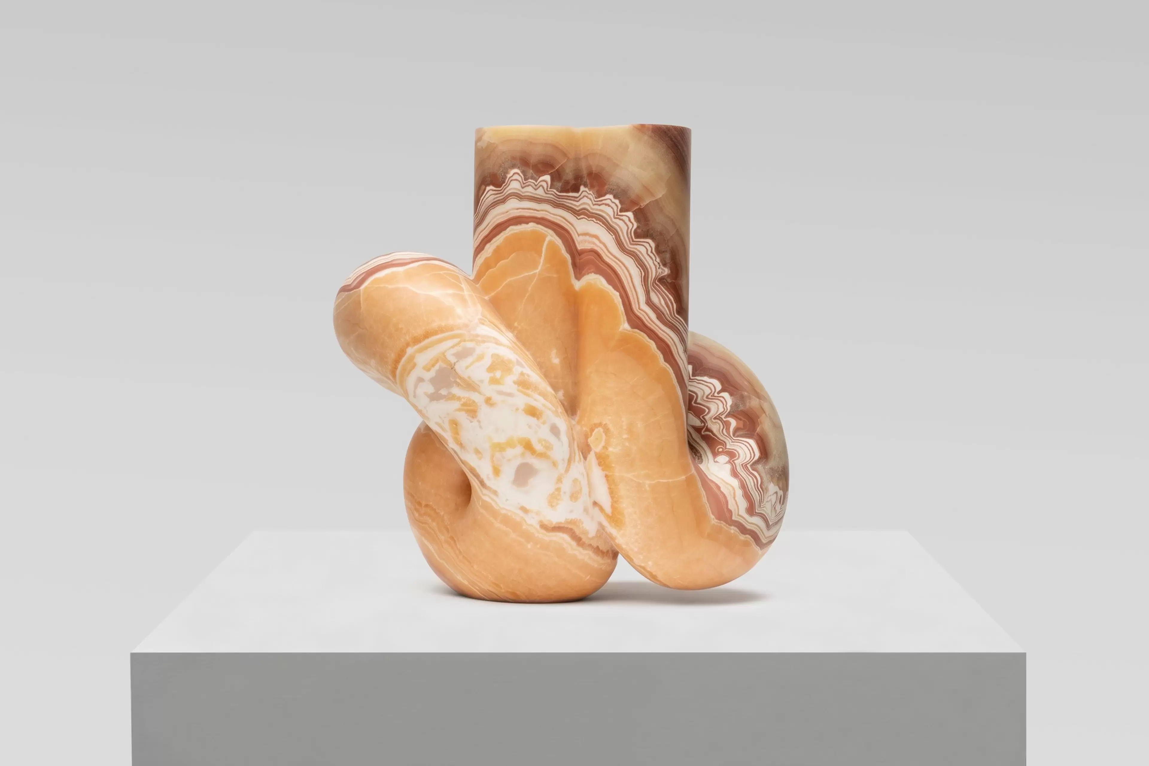 Pedro Reyes, Concordia (2026), red onyx sculpture. Artwork photographed against a white wall.