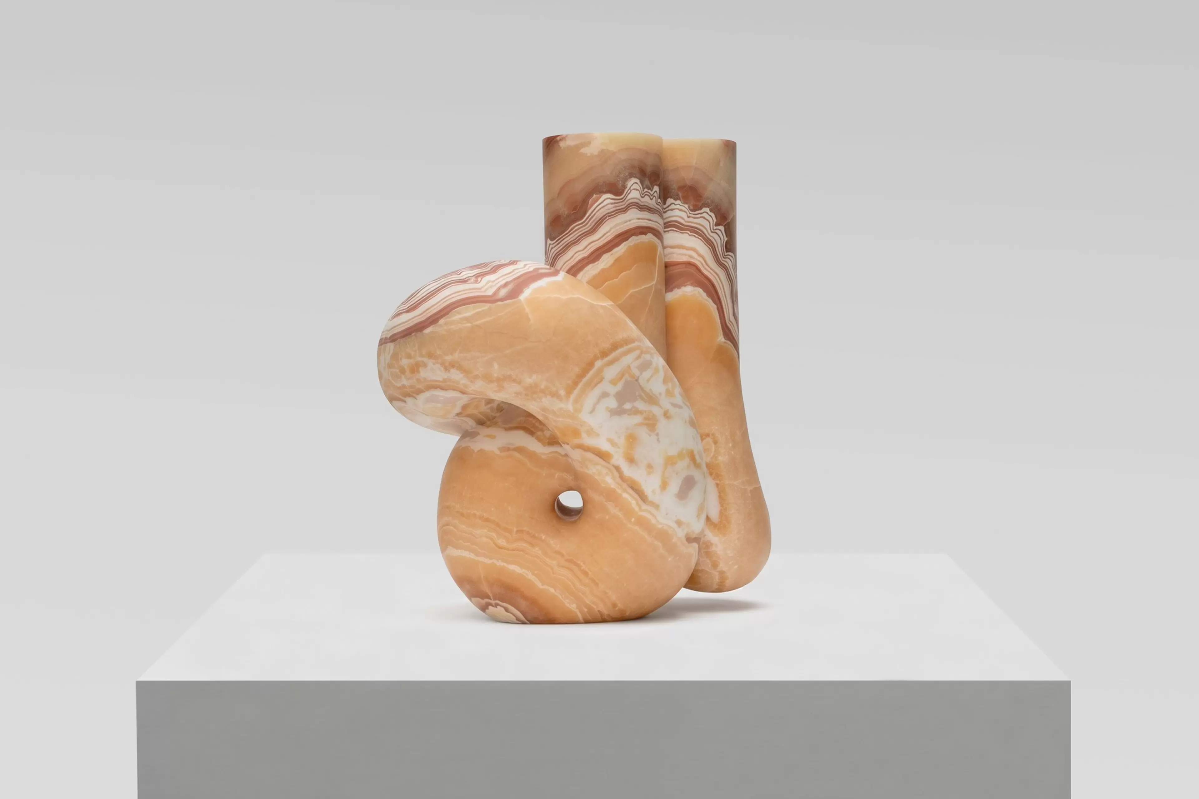 Pedro Reyes, Concordia (2026), red onyx sculpture. Artwork photographed against a white wall.
